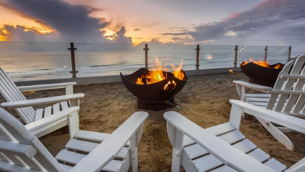 A beachside seating area with white Adirondack chairs and a fire pit. - The Coho Oceanfront Lodge (Lincoln City)