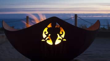 A metal structure with a carved design, possibly a decorative piece or part of a building, set against a twilight sky with clouds.