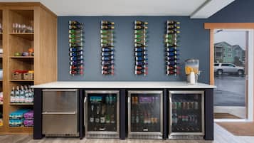 Eine Barbereich mit einer wandmontierten Weinkühler, einem Getränkerefrigeraturkühlschrank und einem Glaskühler.