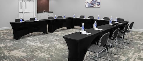 A conference room with a long table, chairs, and water bottles.