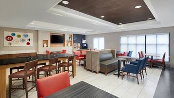 Relax in our inviting lobby, featuring a comfortable seating area, bar, and large flat-screen TV.