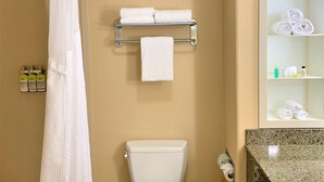 A bathroom with a shower, toilet, towel rack, and shelves with toiletries. - Holiday Inn Express Hotel & Suites FRESNO NORTHWEST-HERNDON by IHG (Fresno)