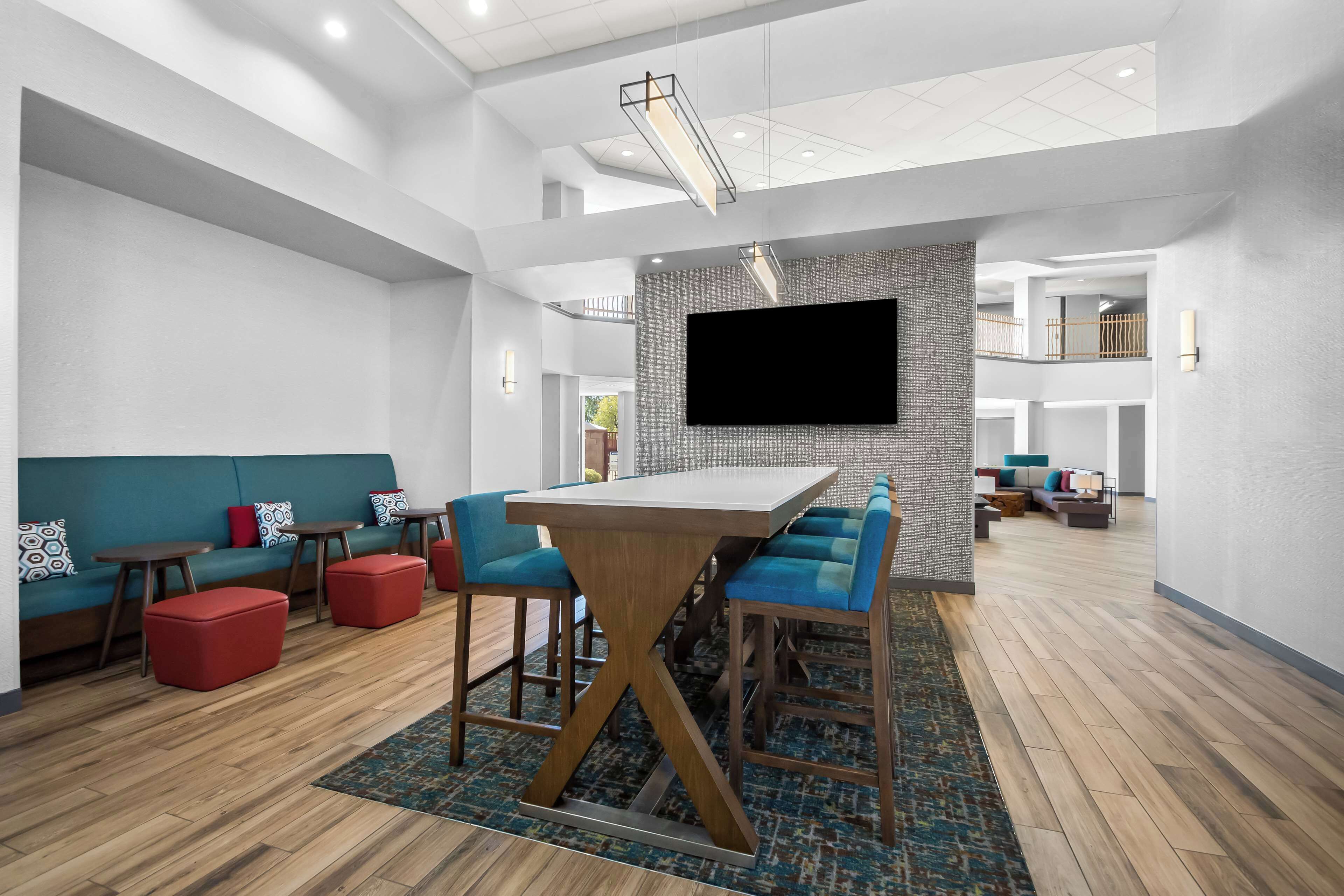 A modern interior with a central bar area, seating, and a mounted TV.