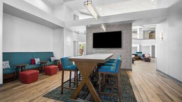 A modern interior with a central bar area, seating, and a mounted TV.