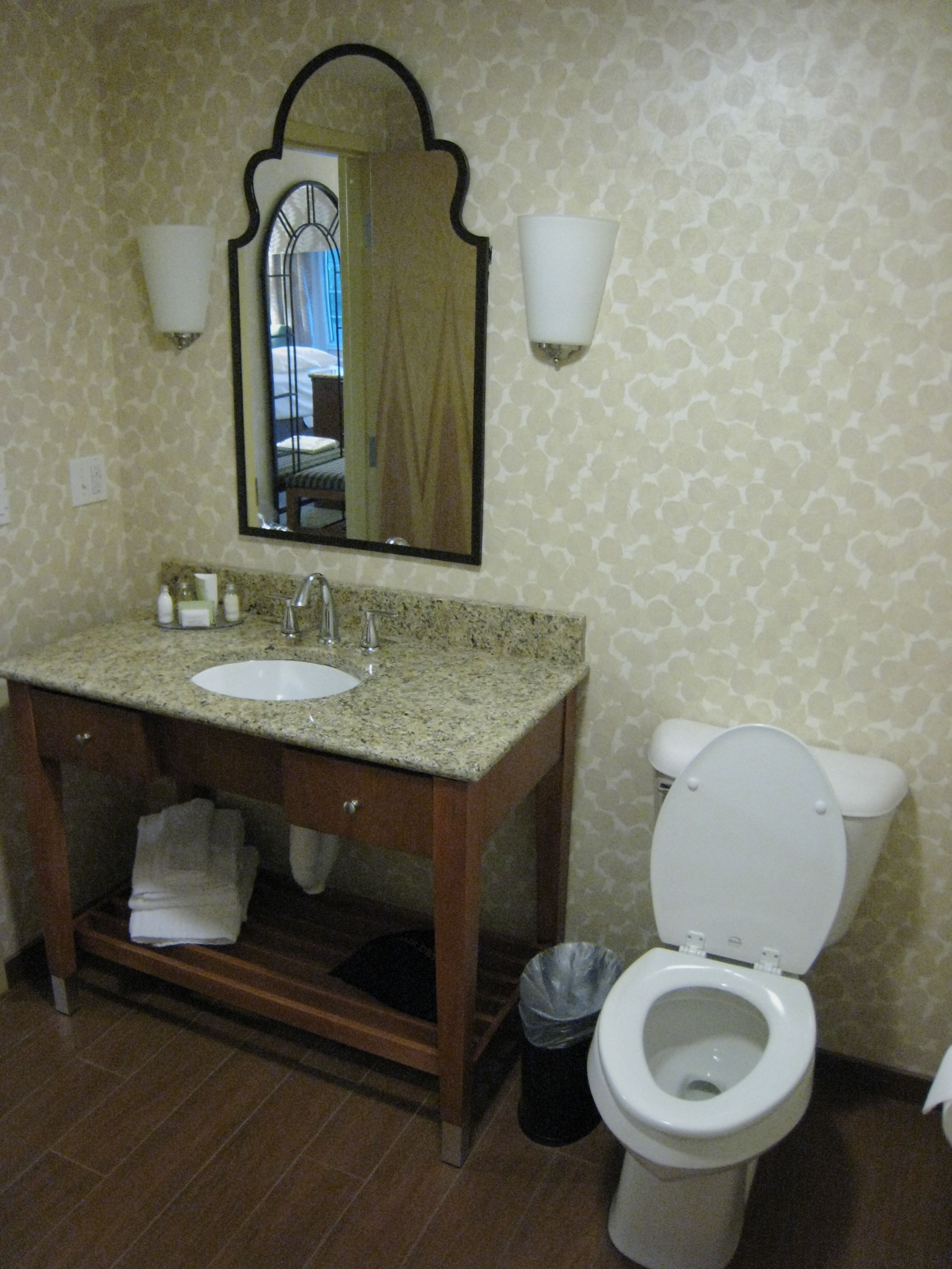 A bathroom with a sink, mirror, and toilet.