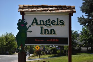 Letrero del Angels Inn con pantalla digital y un personaje de rana.