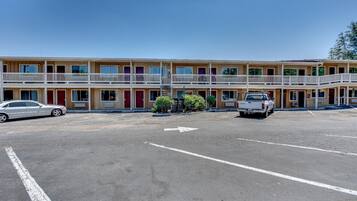 A motel with a parking lot, two-story buildings, and a white pickup truck parked in the lot.