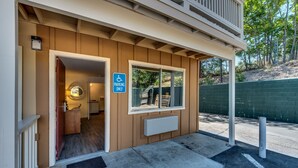 A building entrance with a handicap parking sign, a mailbox, and a small window. - Angels Inn (Angels Camp)