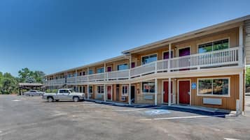Un motel de dos pisos, con varias habitaciones y un área de estacionamiento.