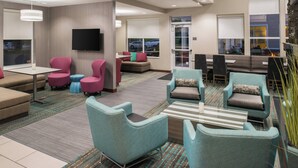 A modern hotel lobby with seating areas, a flat-screen TV, and large windows. - Residence Inn by Marriott Harrisonburg (Harrisonburg)