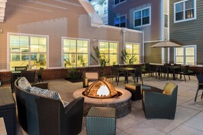 An outdoor patio with wicker furniture, a fire pit, and a brick wall. - Residence Inn by Marriott Harrisonburg (Harrisonburg)