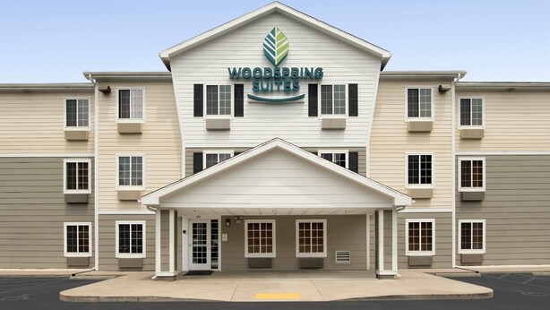 A two-story building with a sign reading "Woodspring Suites." - WoodSpring Suites Spartanburg - Duncan (Duncan)