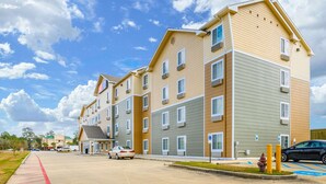 A multi-story residential building with a flat roof, multiple windows, and a parking area with a handicap parking sign. - Econo Lodge Hammond (Hammond)