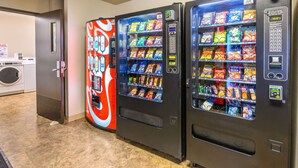 Two vending machines with snacks and a washing machine in the background. - Econo Lodge Hammond (Hammond)