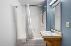 Bathroom features a glass shower enclosure, white sink, and mirror.