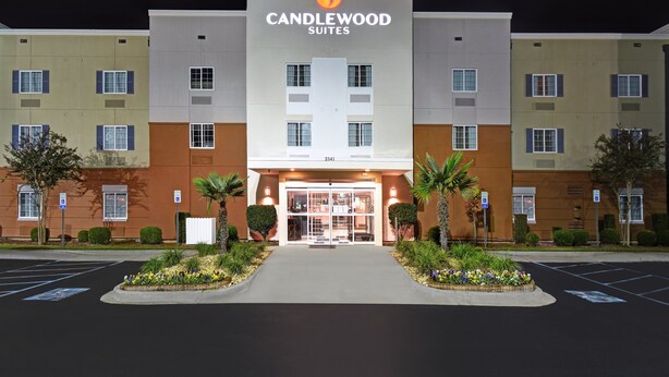 A multi-story hotel with a prominent entrance, a parking lot, and a well-maintained garden area. - Candlewood Suites Sumter by IHG (Sumter)