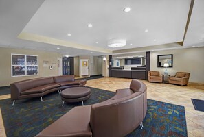 A hotel lobby with a reception desk, seating area, and a large window with a view. - Candlewood Suites Sumter by IHG (Sumter)