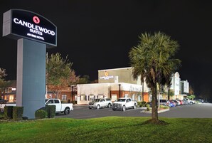 Un letrero de hotel, un estacionamiento y un edificio con un letrero de 'CANDLEWOOD'.