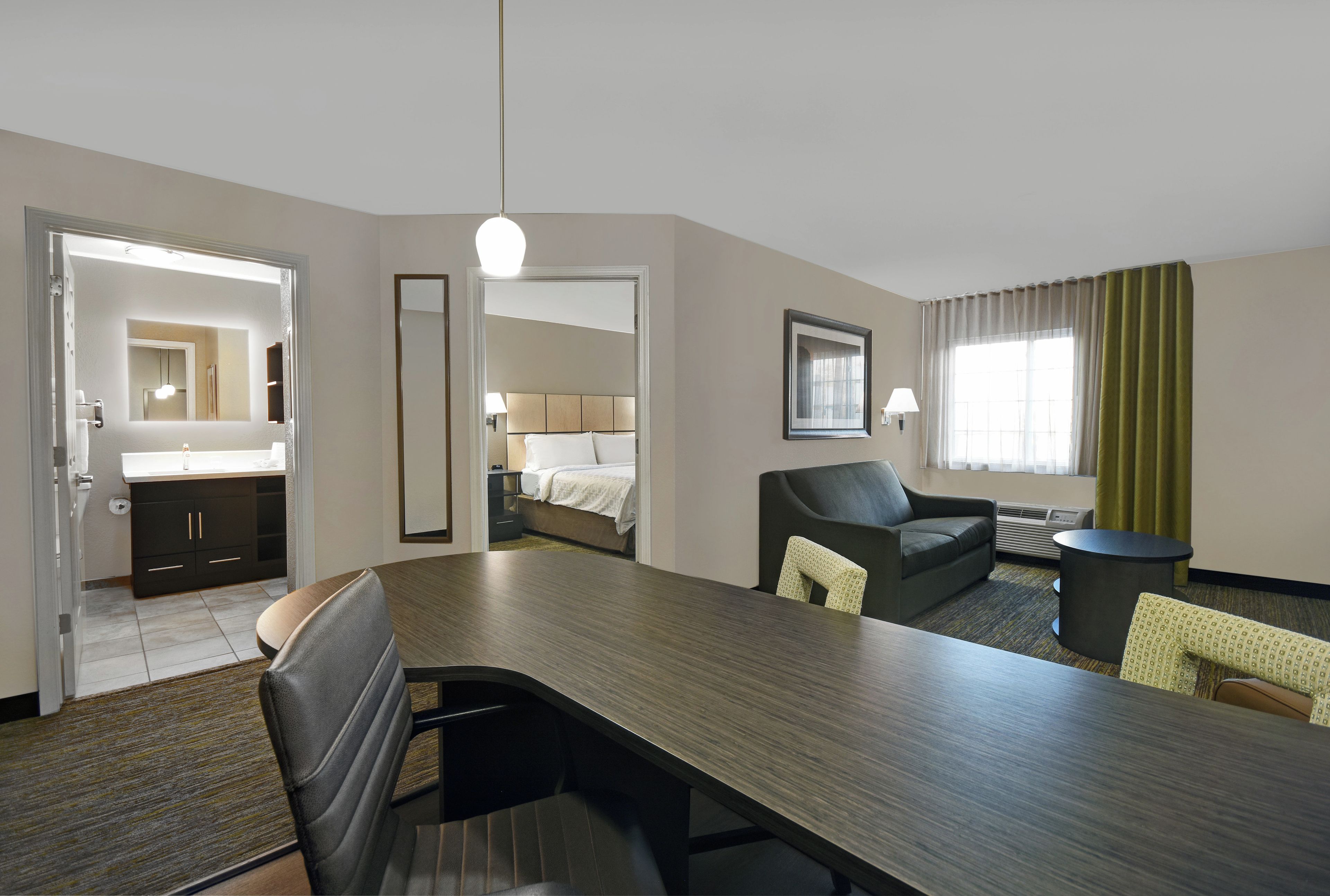 Une chambre d’hôtel comprenant un coin repas, un lit, une salle de bain et donnant sur l’extérieur.