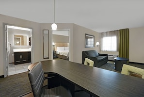A hotel room with a dining area, a bed, a bathroom, and a view of the outdoors. - Candlewood Suites Sumter by IHG (Sumter)