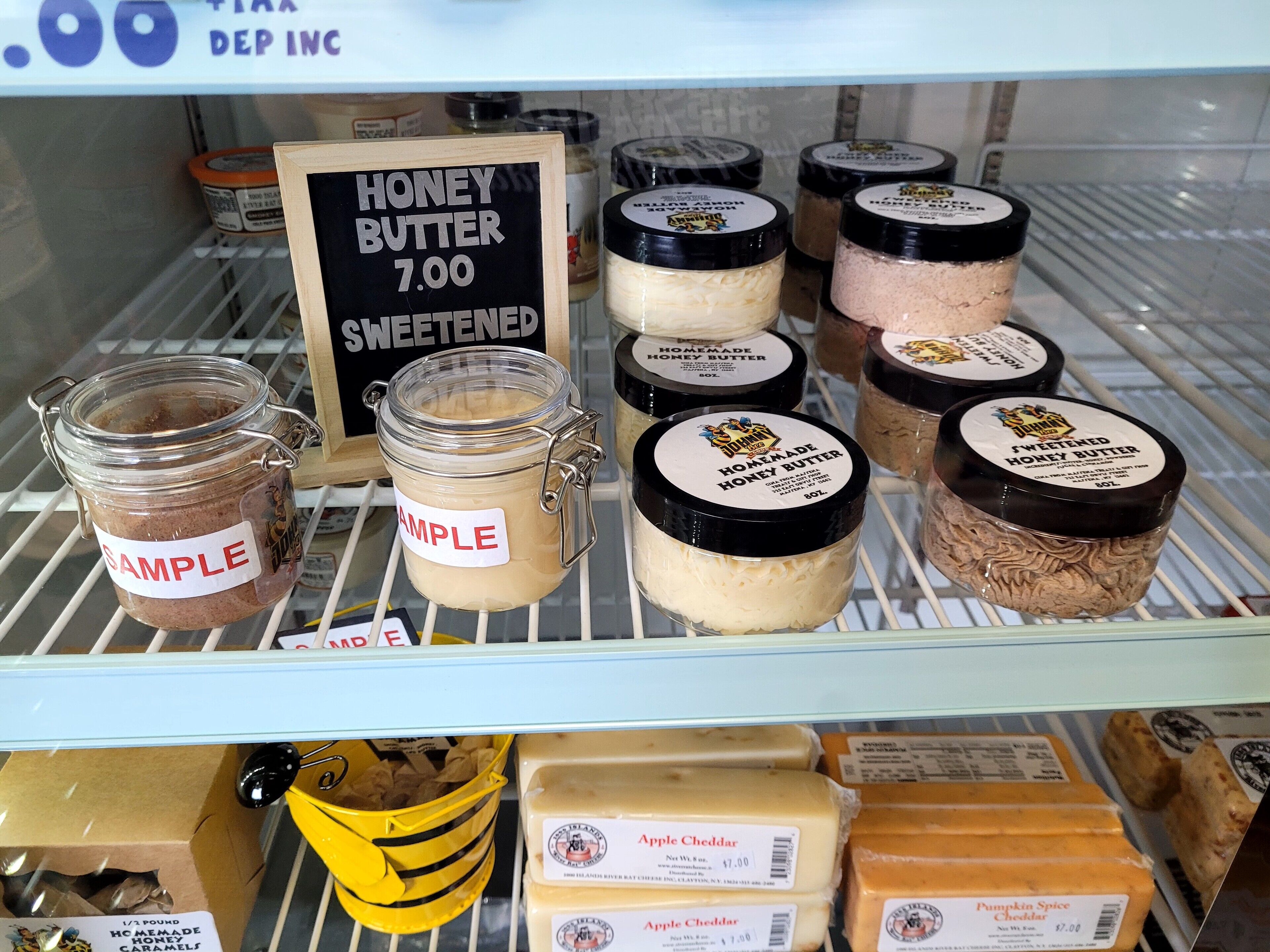 A display of honey butter and other spreads in jars and boxes.
