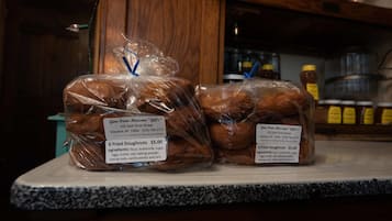 Two packages of fried doughnuts on a counter with labels indicating they are from Gina From Massena's "Gift" and priced at $5.00 each.