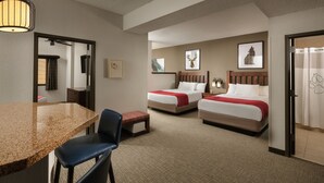 A hotel room with two beds, a dining area with a table and chairs, and a mirror. - Great Wolf Lodge Concord (Concord)