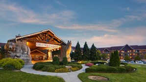A lodge with a prominent sign, stone sculptures, and well-manicured gardens. - Great Wolf Lodge Concord (Concord)