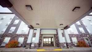 Un edificio moderno con tejado plano, ventanas amplias y fachada de piedra.