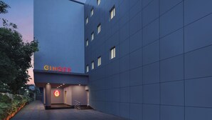 Un edificio moderno con fachada plana, entrada visible y un letrero que dice "GINGER".
