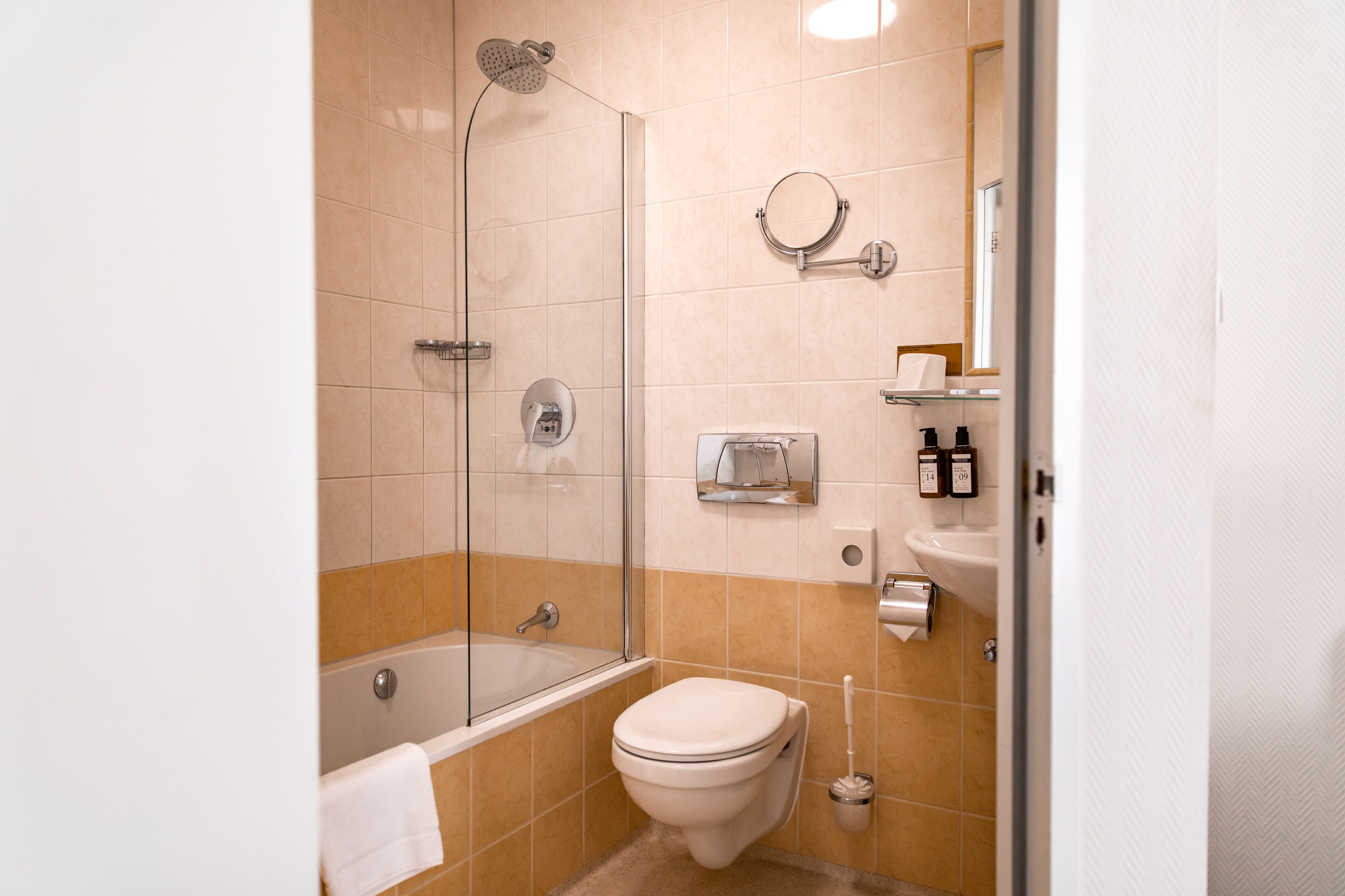 Un baño moderno con ducha envuelta en vidrio, inodoro y lavamanos.