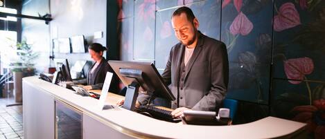 A reception desk with a modern design, featuring a curved counter and a digital display.