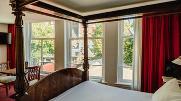 Ein Himmelsbett mit Blick auf eine Straße durch große Fenster.
