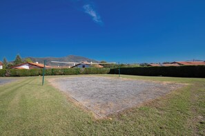 A well-maintained outdoor area with a tennis court, surrounded by neatly trimmed hedges and a clear blue sky. - VVF Résidence Pays Basque Saint-Jean-Pied-de-Port (Saint-Jean-Pied-de-Port)