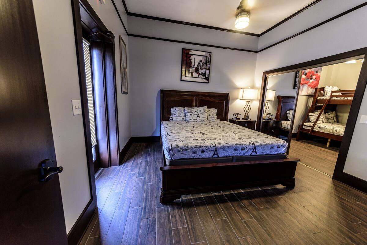 A bedroom with a wooden bed, a nightstand, a lamp, and a mirror.