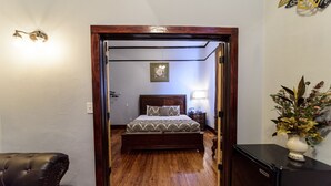 Une chambre à coucher avec un lit en bois, une table de chevet, une lampe et un petit réfrigérateur.