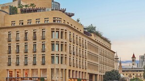 A large, curved hotel building with multiple floors, balconies, and a prominent tower. - Le Gray (Beirut)