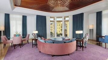 Un moderno vestíbulo de hotel con una zona de estar circular, ventanas amplias y un techo decorativo.