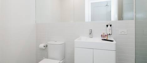 Une salle de bain moderne avec des toilettes, un lavabo et un miroir.