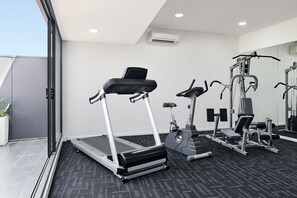 Ein modernes Fitnessstudio mit Laufbändern, Crosstrainern und Gewichtsgeräten.