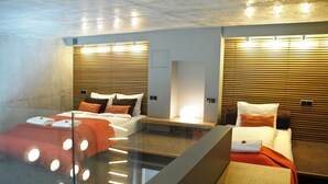 A modern hotel room with a glass partition, two beds with different bedding, wooden headboards, and built-in lighting. - La Gioia Designers Lofts Luxury Apartments (Kraków)