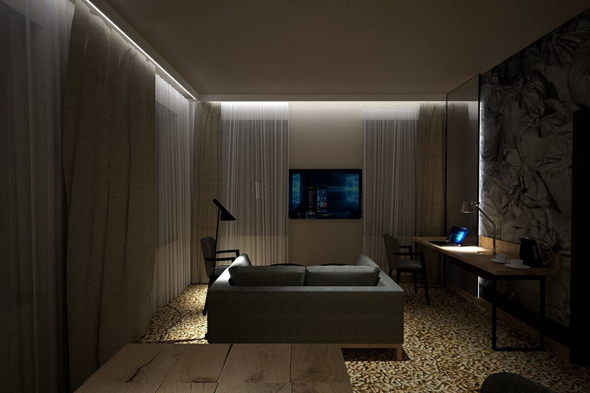 A modern living room with a sofa, a desk, and a flat-screen TV mounted on the wall.