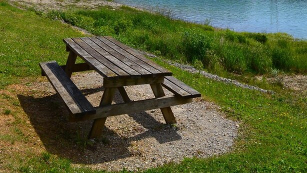 A picnic table by a lake with boats in the background. - VVF Jura Lac de Vouglans, Maisod (Maisod)