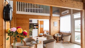 A wooden interior with a dining area, a kitchen, and a living room with a large window.