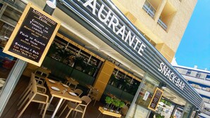 A restaurant with outdoor seating and a signboard listing menu items. - Hotel Apartamentos Foz Atlântida (Vila Real Santo Antonio)
