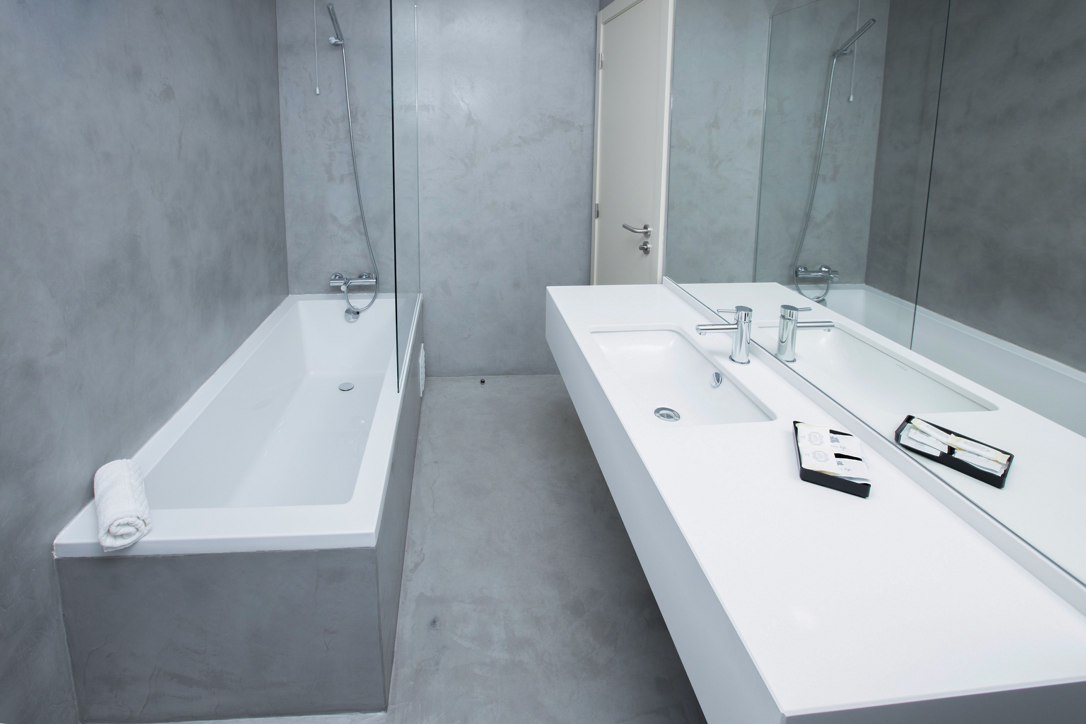 Ein modernes Badezimmer mit einer großen Badewanne, einem langen Waschtisch mit Spiegel und einer Duschkabine.