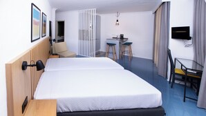 A hotel room with a large bed, a desk with two chairs, a TV, and a small table. - Hotel Apartamentos Foz Atlântida (Vila Real Santo Antonio)