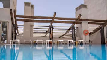 Piscine extérieure, parasols de plage, chaises longues
