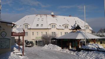 Ein Hotel mit verschneitem Dach und einem Schild, das ein Restaurant anzeigt.
