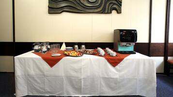 A table set with various food items and a coffee machine, indicating a dining area in a hotel.